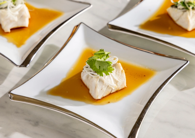 ねぎ油をかけて仕上げる鱸と香港醤油ソース